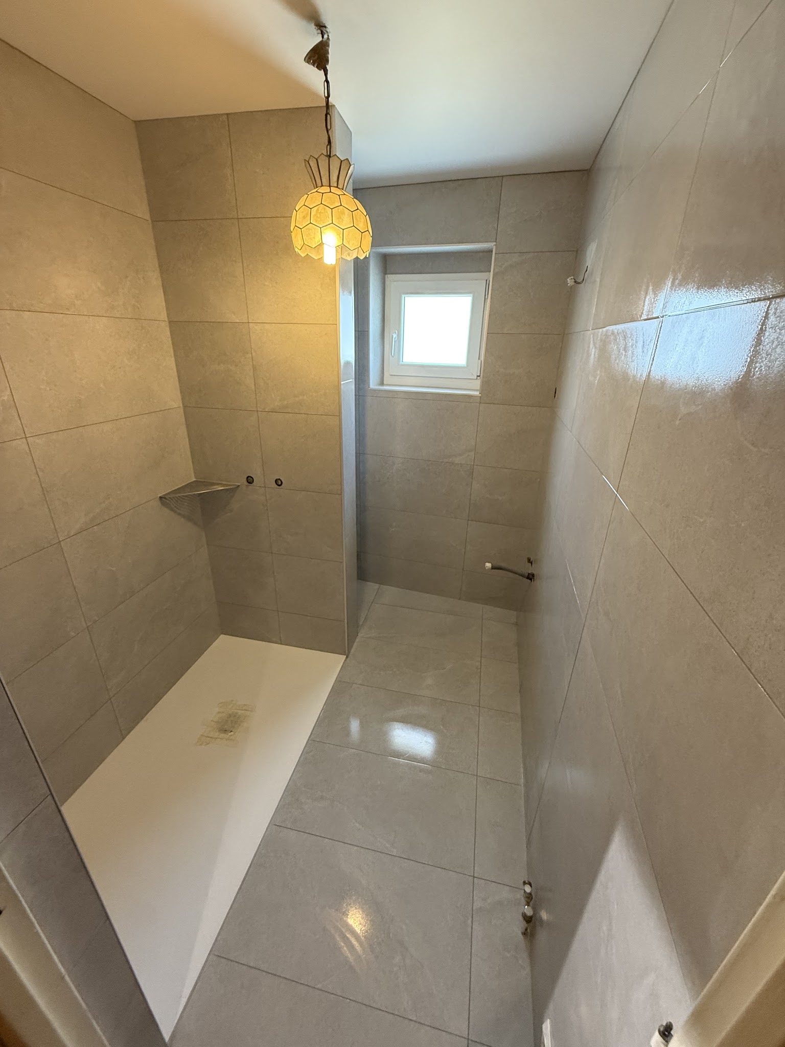 Salle d'eau terminée en grand format gris, receveur blanc