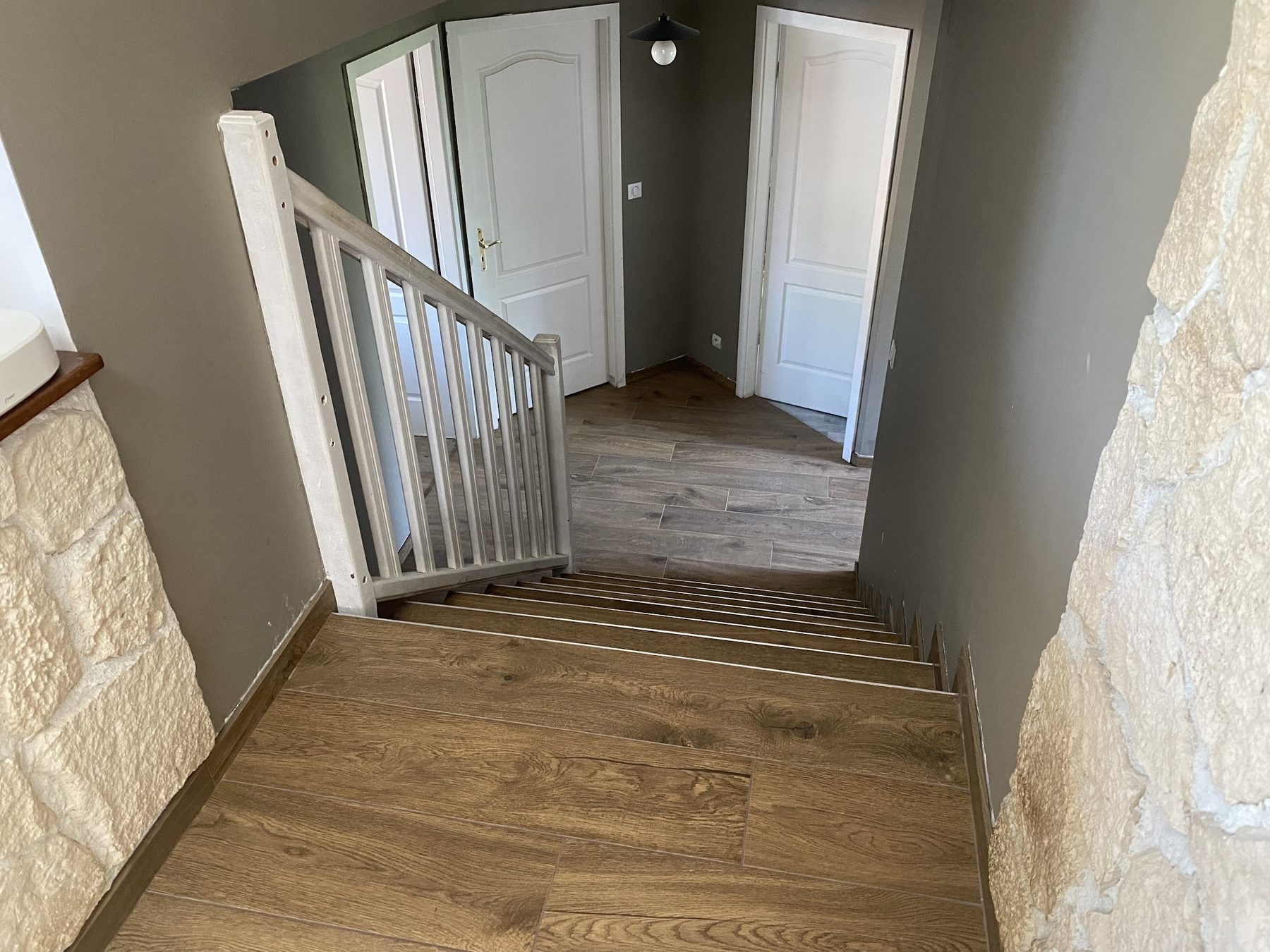 Escalier et palier en grès effet bois, mur en pierre